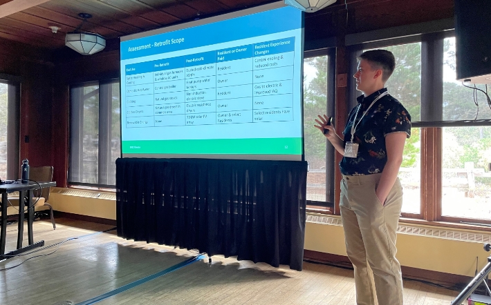  Elevate employee presenting at an event pointing to a screen