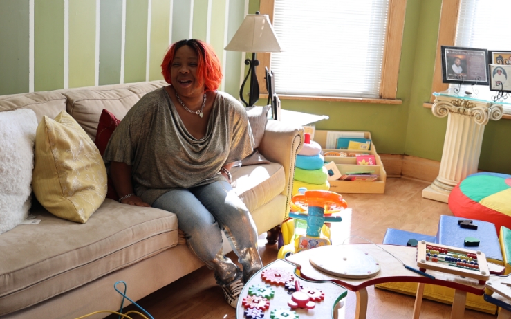 Woman sitting on a couch in a living room with children’s toys around