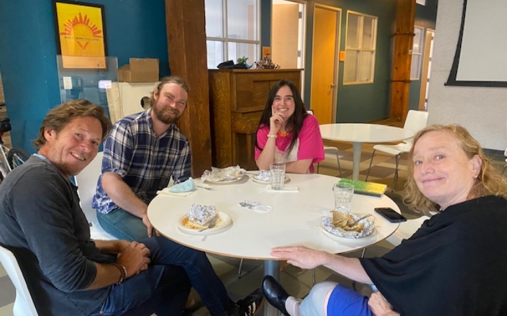 Group of Elevate employees sitting around a table in an office