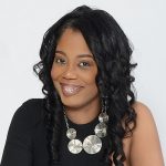 Image of Black woman with dark hair smiling at camera.