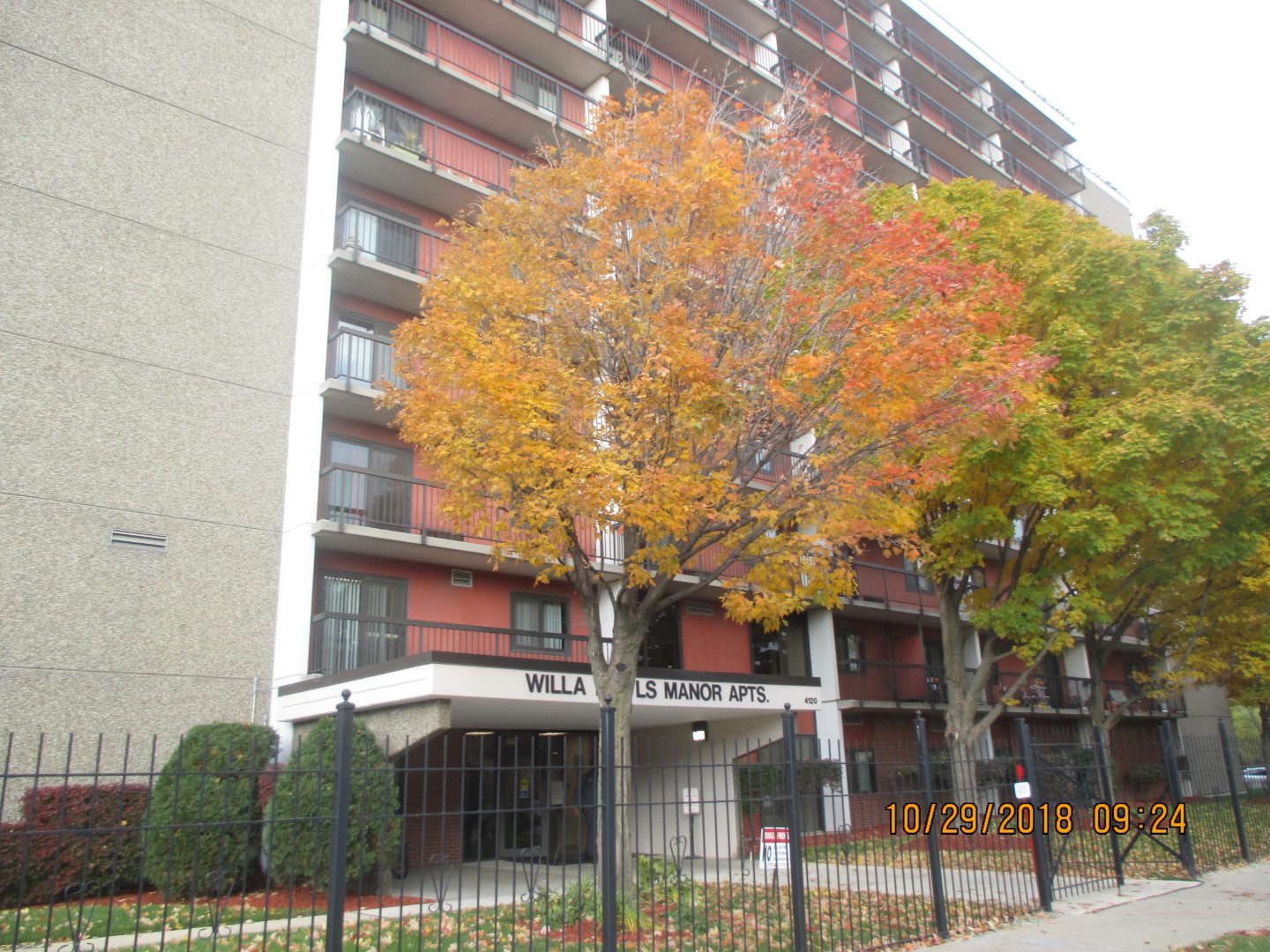 Exterior of multifamily building with large trees in front