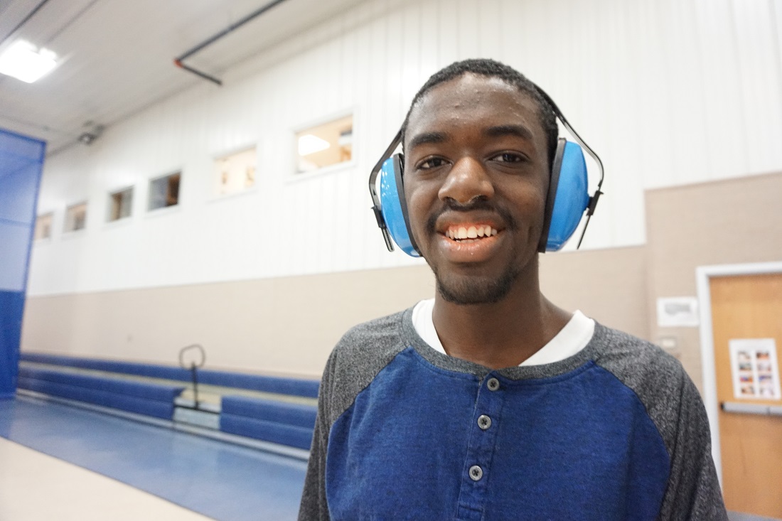 Young man with hearing sensitivity headphones smiling at the camera