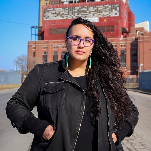 Image of Latina woman with glasses wearing a black jacket.