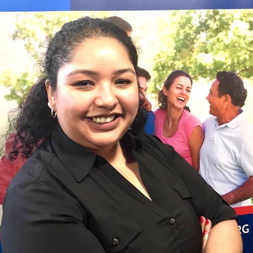 Image of Latinx woman smiling at camera and wearing a black shirt