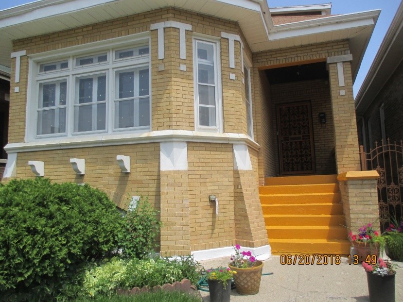 Front of a single family home with yellow brink and white trim.
