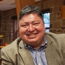 Picture of Native American man wearing a blazer and smiling