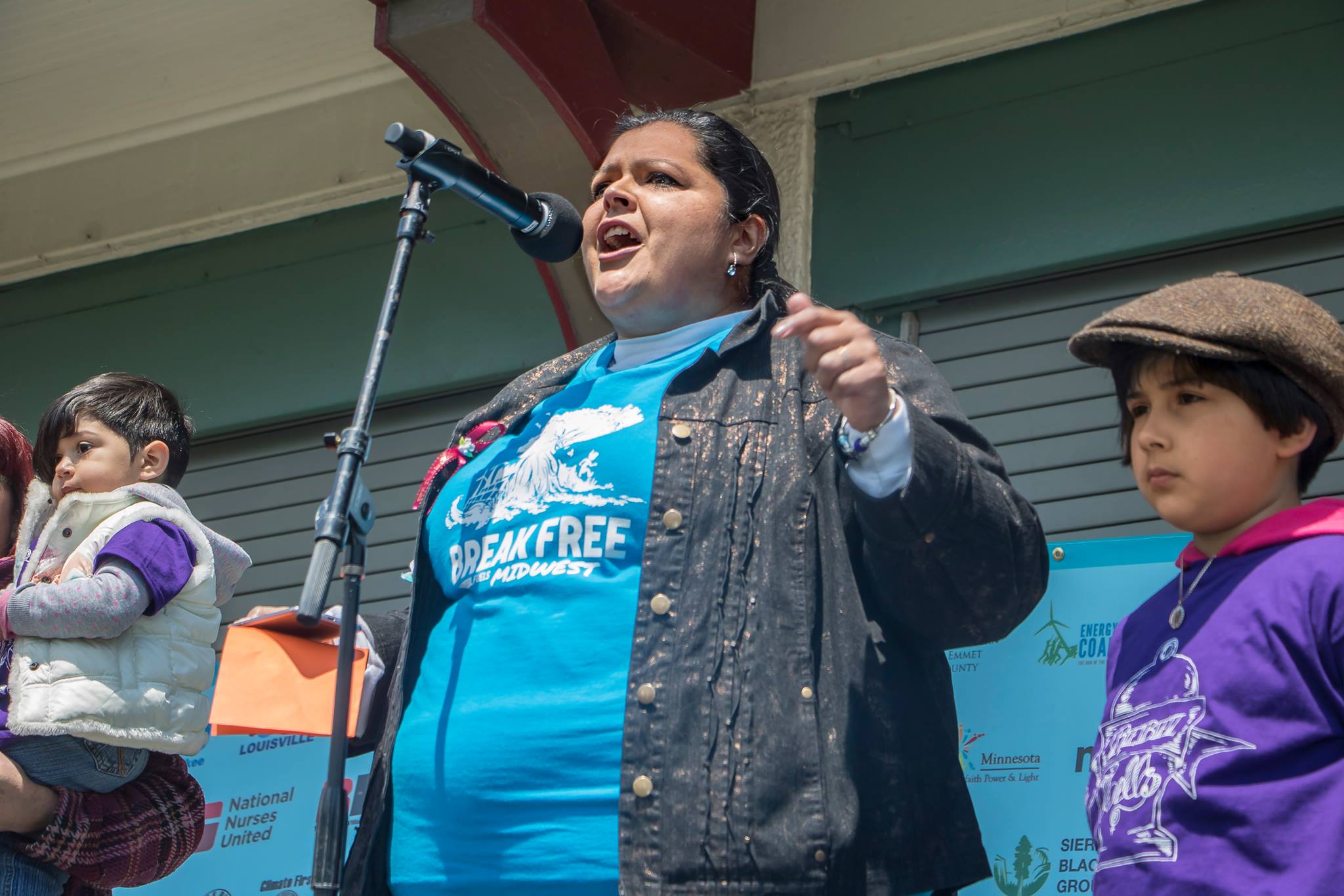 Woman speaking into a microphone at a rally
