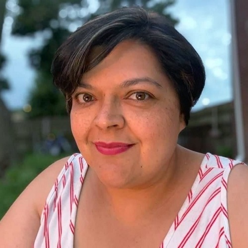 Image of Latina woman with short hair smiling at the camera.
