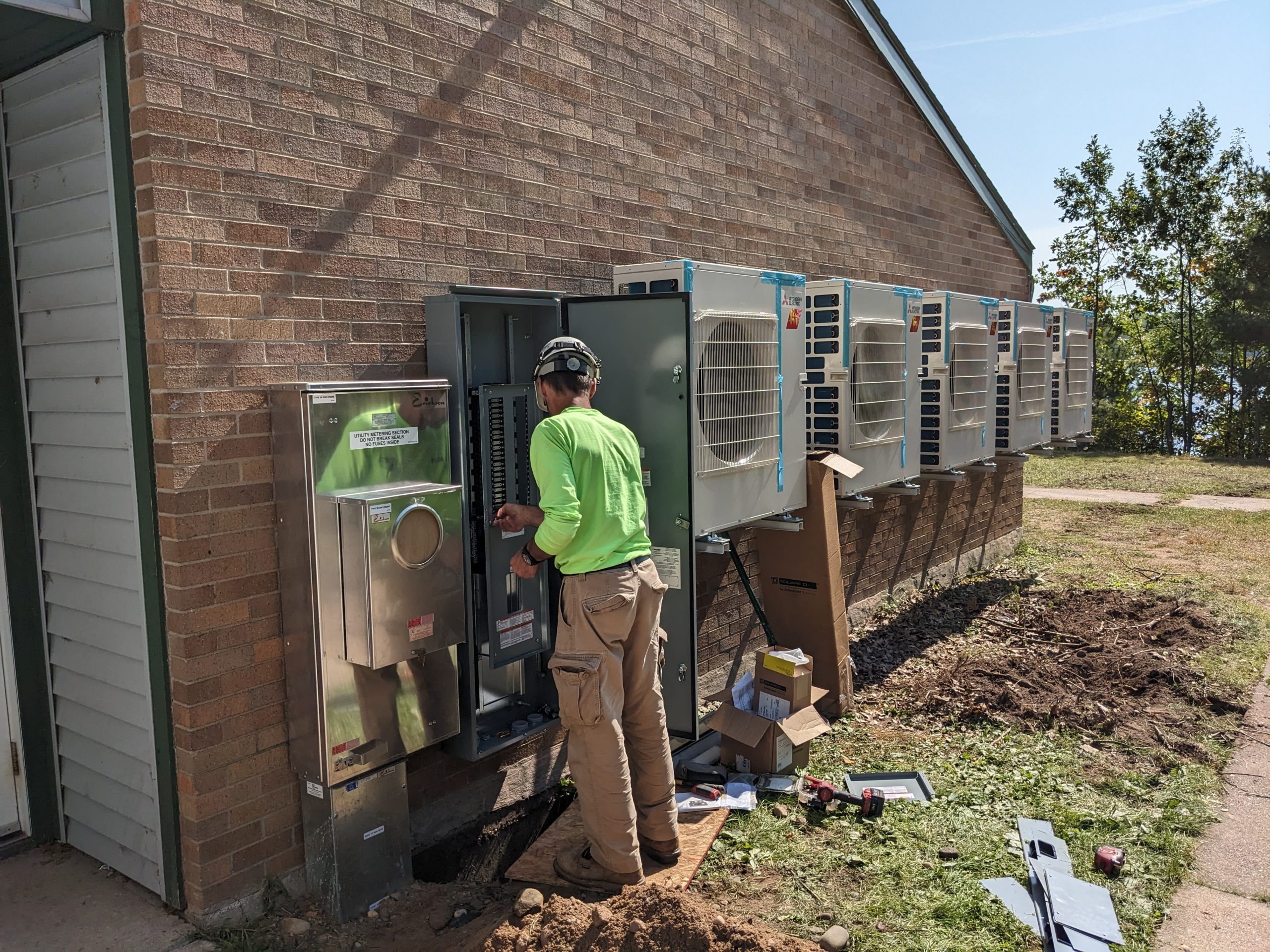 Person working on heat pumps outside 