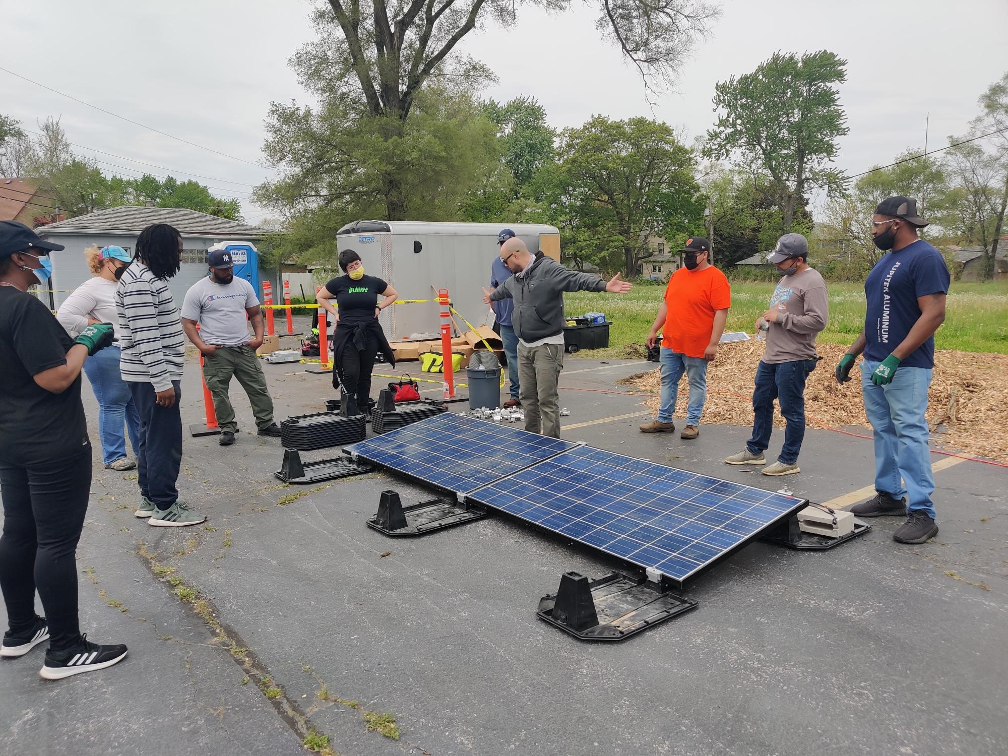 Group of people outside looking at a solar panel