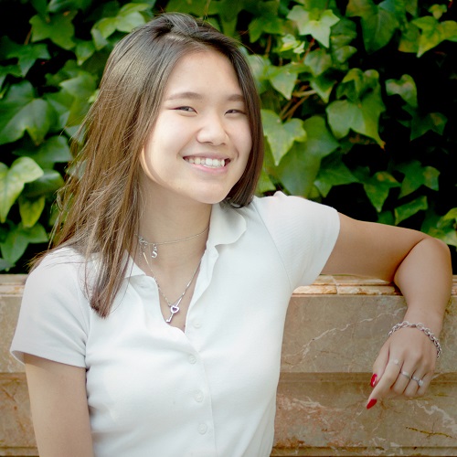 Image of young Asian woman sitting outside