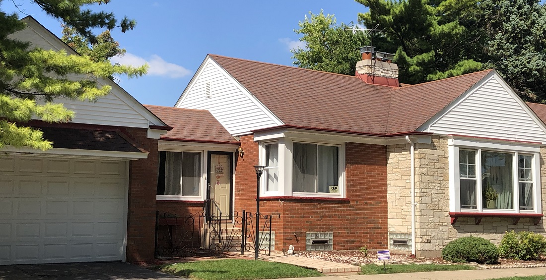 Exterior of single family home with white siding and red roof