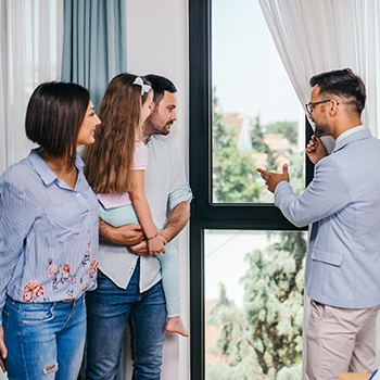 professional showing a home to a family