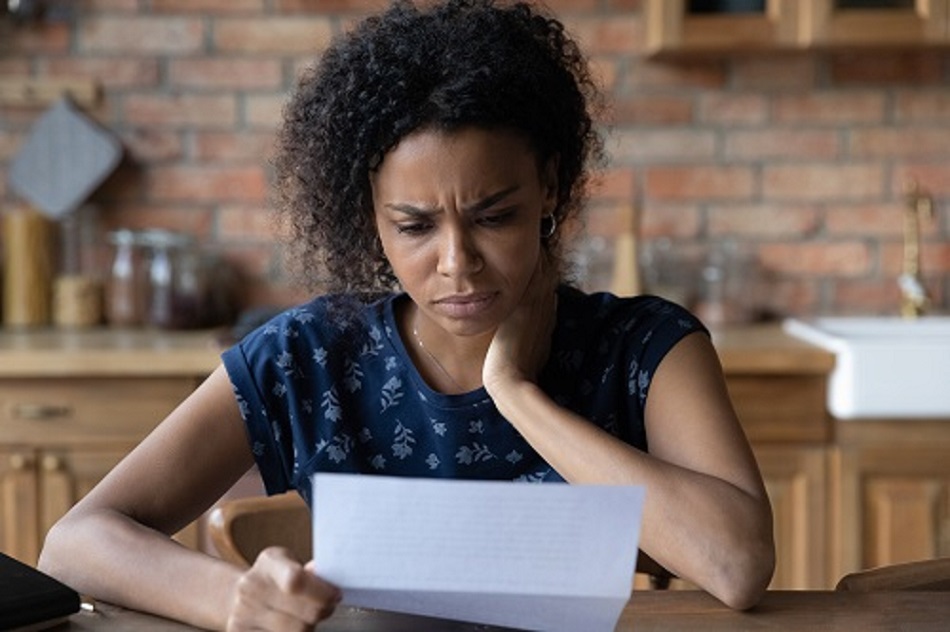 Close up unhappy African American young woman reading letter, document, frustrated businesswoman or student received bad news, unexpected debt or job dismissal notification, financial problem 